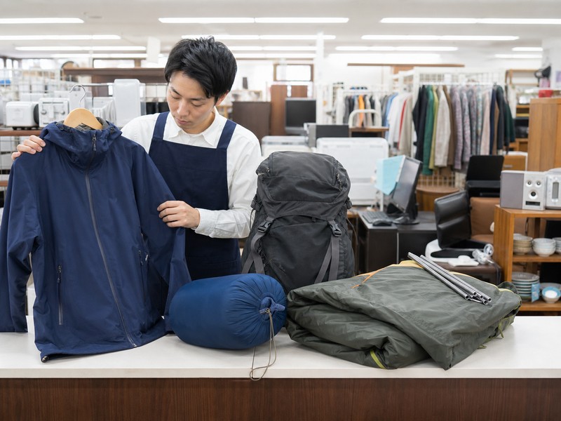 総合リサイクルショップで複数のモンベル登山用品を査定するスタッフ